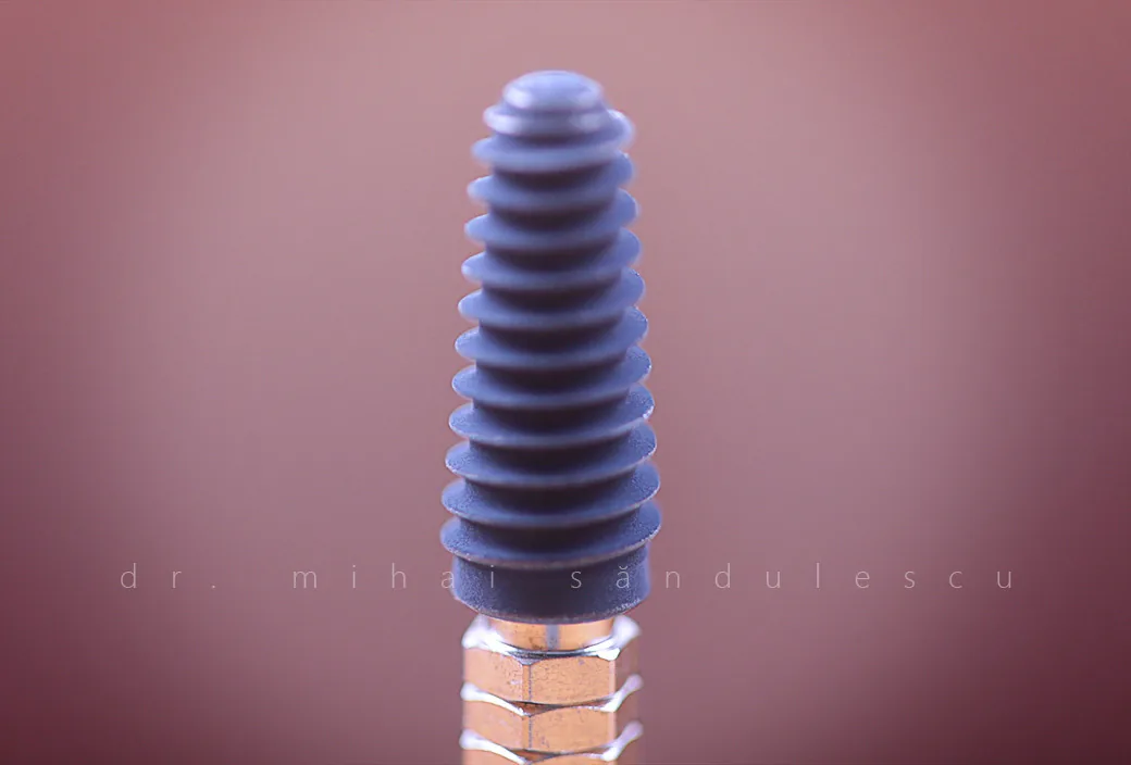Un implant dentar, fotografiat macro înainte de inserare.